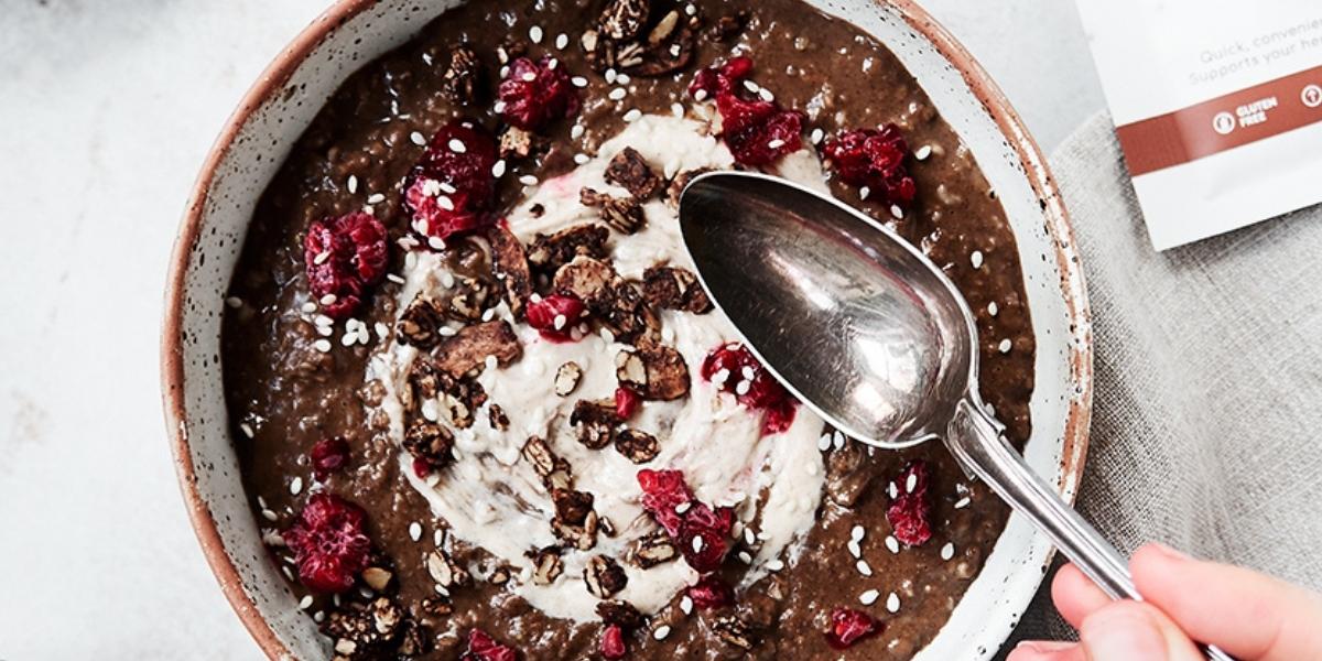 Protein porridge; Chocolate & oat porridge bowl topped with raspberries.