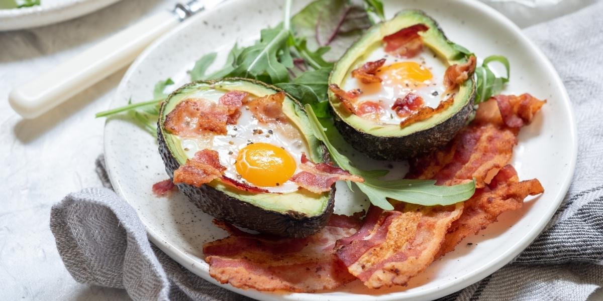 High protein, low-carb breakfast idea; baked avocado with eggs, bacon and rocket.