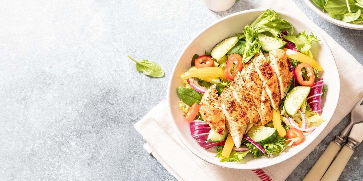 Grilled chicken breast and colourful mixed salad bowl.