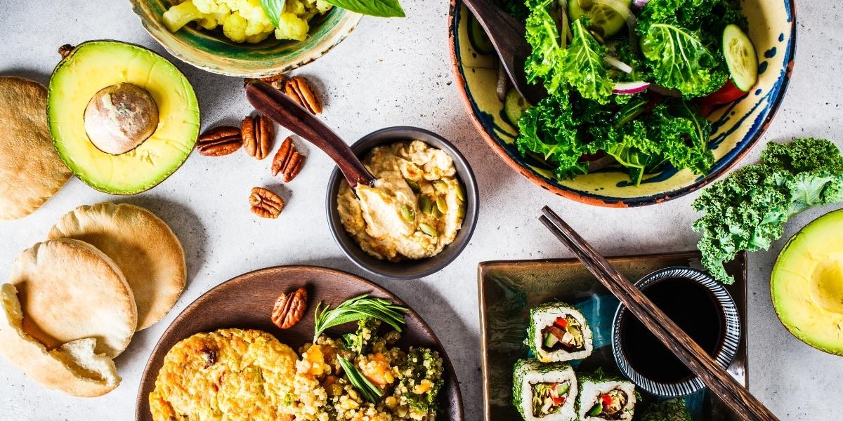 Plates of food; Kale salads, flat breads, dips and vegan sushi rolls.