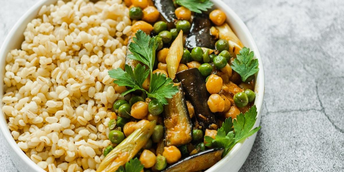 Vegan curry; Rice bowl with curried aubergine, green and chick peas topped with corriander.