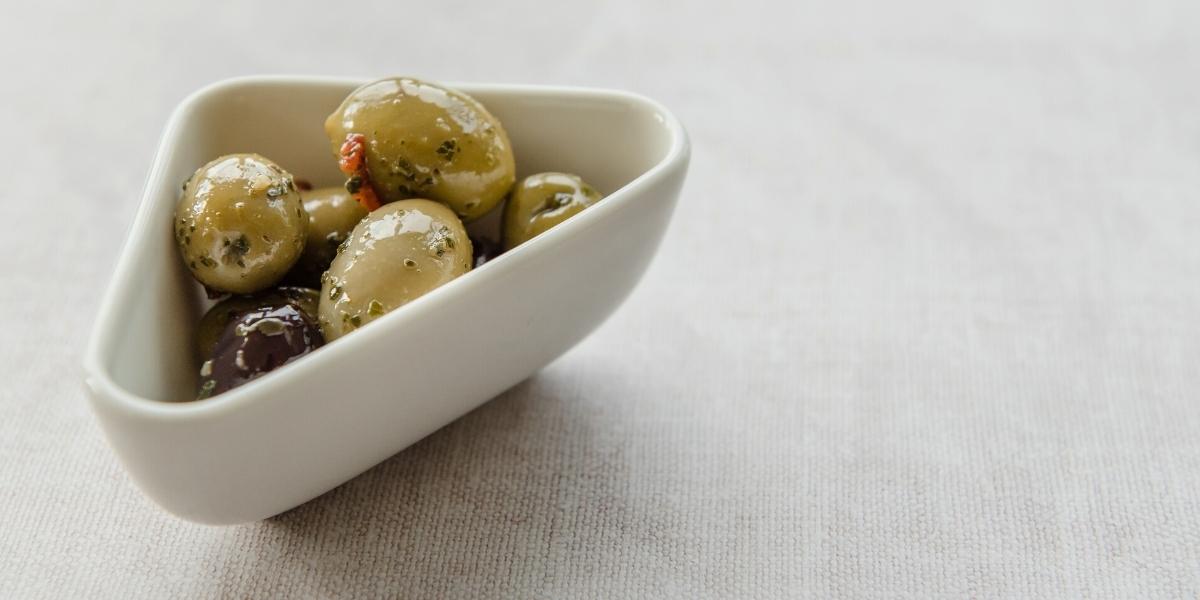 Small bowl of mixed olives in herby olive oil.