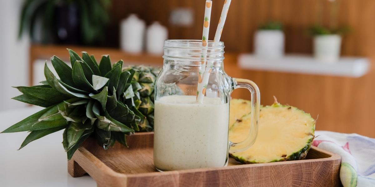 Fresh pineapple smoothie with straws in a kilner jar