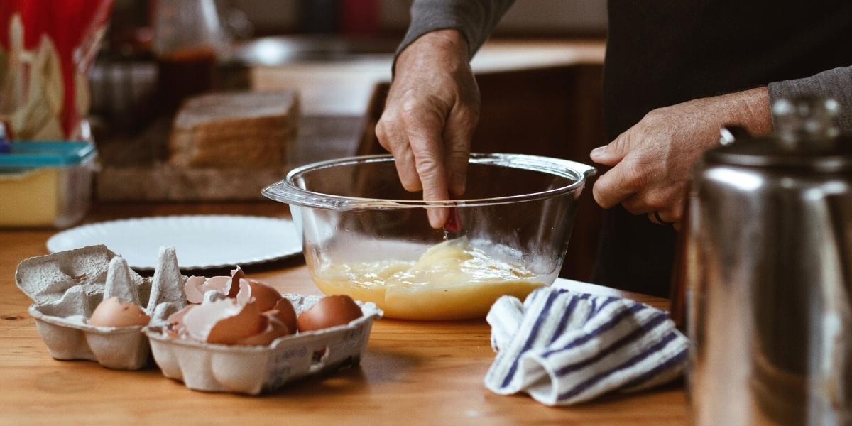 Person beating some eggs in a bowl about to make scrambled eggs.