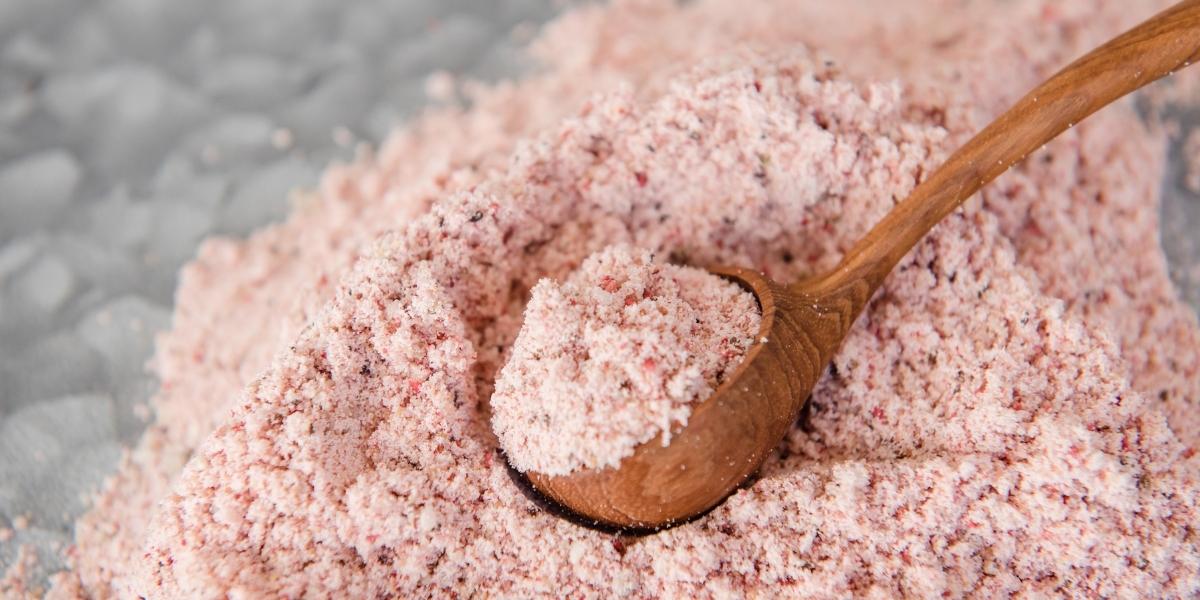 Purition Strawberry wholefood nutrition powder made with whey protein isolate spilling out onto work surface.