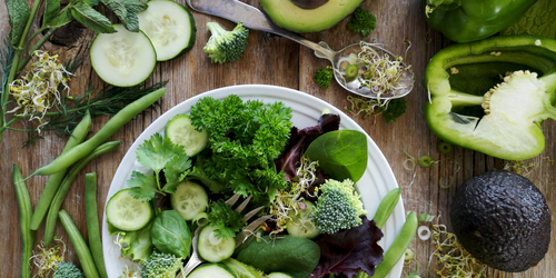 Green vegetables on plate including cucumber, spinach and green pepper