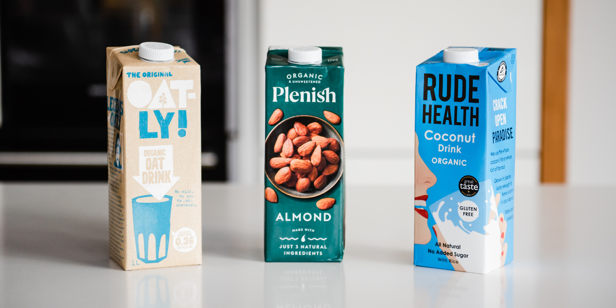 A row of nut milk cartons; Oatly, Plenish & Rude Health